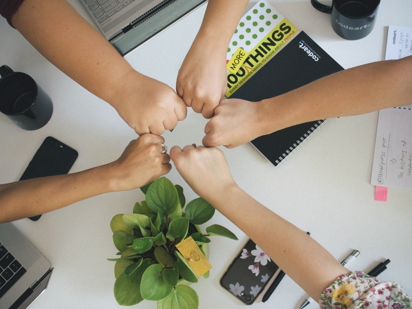 A team bumping fists over a desk